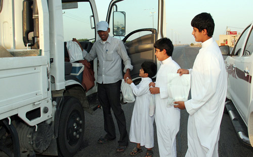 الصغار يشاركون في إفطار المسافرين بخيرية القصب 