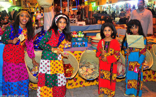 فتيات يرتدين الزي الشعبي التقليدي فى سوق الأسر المنتجة 