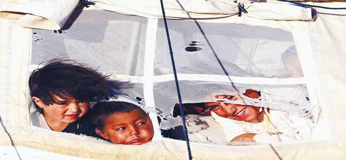 خلف خيوط هذه الخيمة المهترئة يقبع ثلاثة أطفال بابتسامة عريضة 