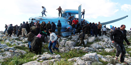  مواطنون ومسلحون يبحثون عن طاقم المروحية السورية