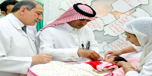  مدير المستشفى يعطي الجرعة لأحد الرضع