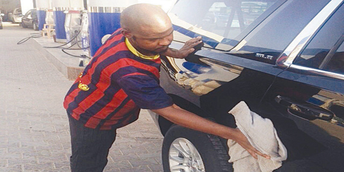  الشاب الغاني يمارس عمله في غسيل السيارات