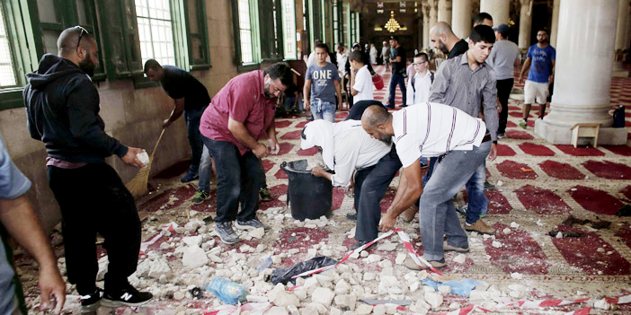  فلسطينيون يزيلون آثار الدمار والخراب الذي ارتكبته قوات الاحتلال في المسجد الأقصى