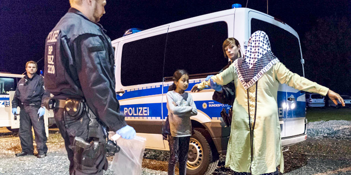  شرطية تجري تفتيشاً أمنياً لإحدى اللاجئات وابنتها على الحدودِ الألمانيةِ النمساويةِ