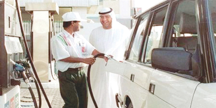  عامل يقوم بتعبئة الوقود ومالك السيارة يبتسم له في محطة وقود بدبي