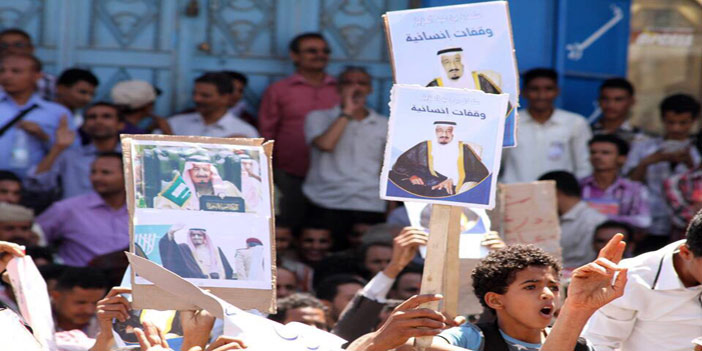  يمنيون يرفعون صورة للملك سلمان