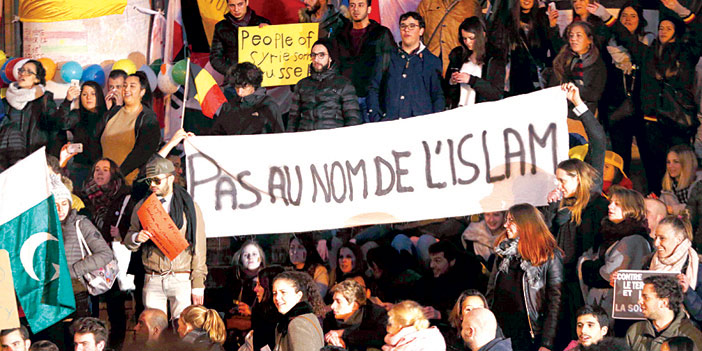  متظاهرون مسلمون يرفعون لافتة باللغة الفرنسية «هذا ليس باسم الإسلام» إشارة إلى تفجيرات بروكسل