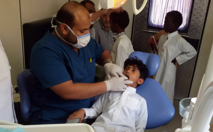  طبيب يفحص أسنان أحد الطلاب