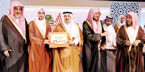  أمير الرياض خلال تكريمه أحد الفائزين من جمعية تحفيظ بريدة