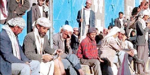   مجموعة من اليمنيين يجلسون على قارعة الطريق علهم يجدون فرصة عمل