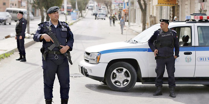 رجلان من الأمن الأردني يغلقان الطريق في مخيم البقعة