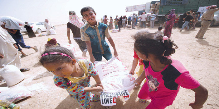  أطفال عراقيون نازحين من الفلوجة  يحملون المساعدات الغذائية