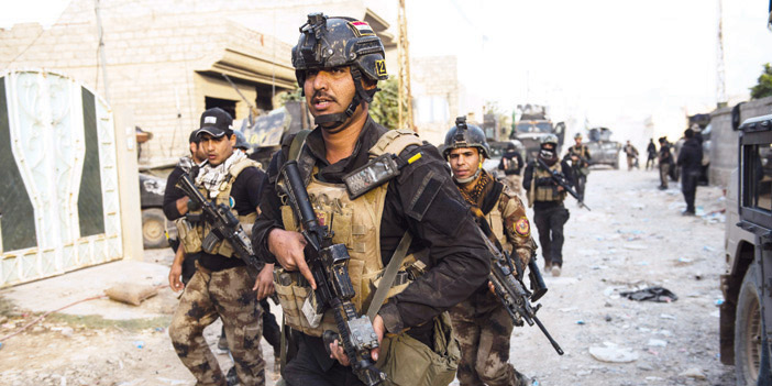  جنود من القوات العراقية أثناء تقدمهم في أحد أحياء الموصل