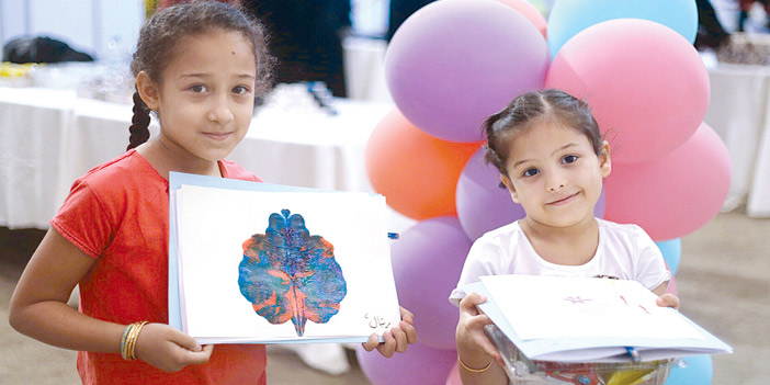  طفلتان تحملان أعمالهما الفنية
