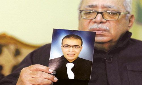  والد المتهم يشير إلى صورة إبنه المتهم عبدالله الحماحمي
