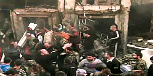  آثار الانفجارات الانتحارية الثلاثة التي استهدفت مقرات أمنية في حمص