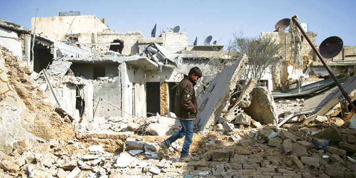  طفل سوري يمشي بين أنقاض المباني المهدمة جراء قصف النظام عليها