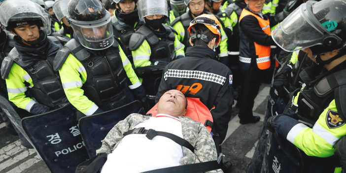  رجل مُسن يحمله مسعفون خلال الاحتجاجات بكوريا الجنوبية