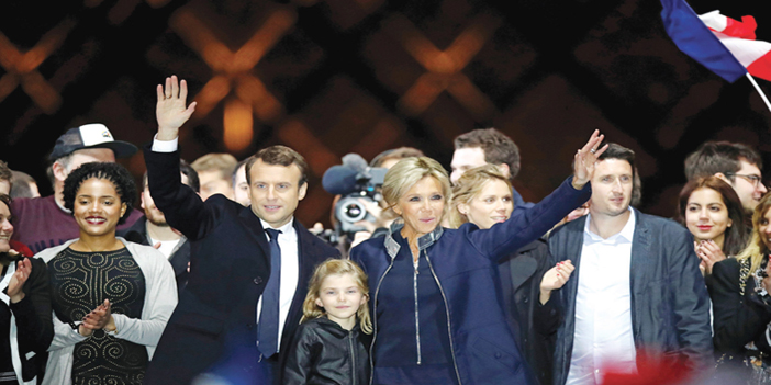  الرئيس الفرنسي ماكرون برفقة زوجته بريجيت ترونوكس يحيي مناصريه وناخبيه عقب فوزه بالانتخابات