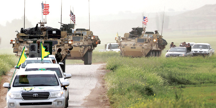  مقاتلون أكراد برفقة قافلة عسكرية أمريكية قرب بلدةِ دارباسيا على الحدودِ التركية