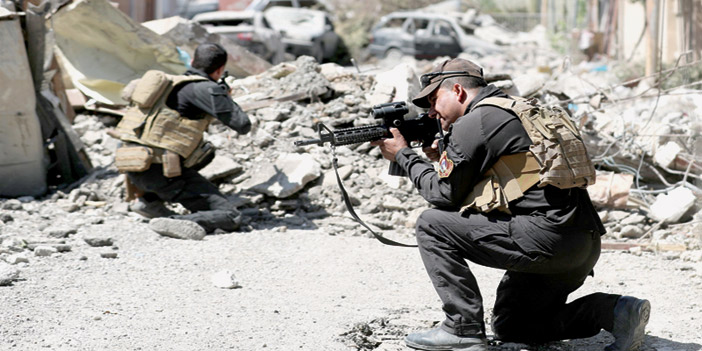  عنصران من القوات العراقية أثناء الاشتباك مع داعش بالموصل