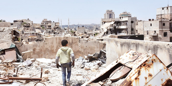  طفل سوري يسير بين حطام المباني جراء قصف النظام المتكرر