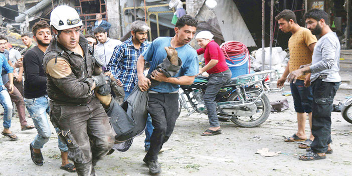  رجال الإنقاذ يحملون مصاباً من جراء غارات النظام على مدينة ادلب