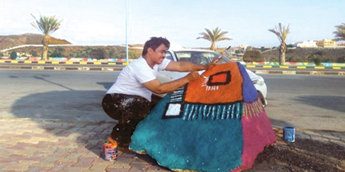  الفنان البارقي خلال تنفيذه لأحد أعماله الميدانية