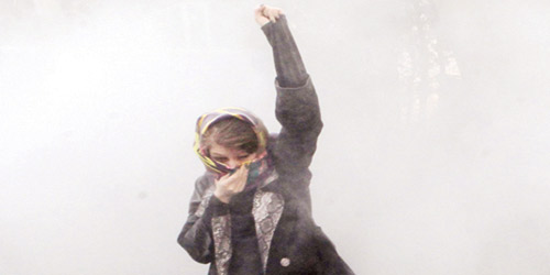 طالبة من جامعة طهران تحتمي من الغازات المسيلة للدموع
