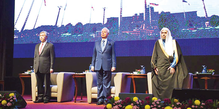  د. العيسى مع رئيس الوزراء الماليزي ونائبه على المنصة الرئيسية في حفل افتتاح المؤتمر