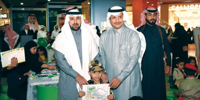  وكيل محافظة الرس ومدير التعليم مع طفل مشارك بالمعرض