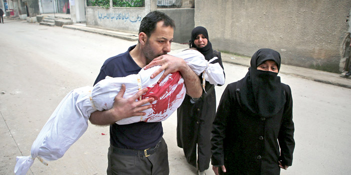  سوري وزوجته يشيعان جثمان طفلهما الذي قضى في غارات للنظام على زملكا