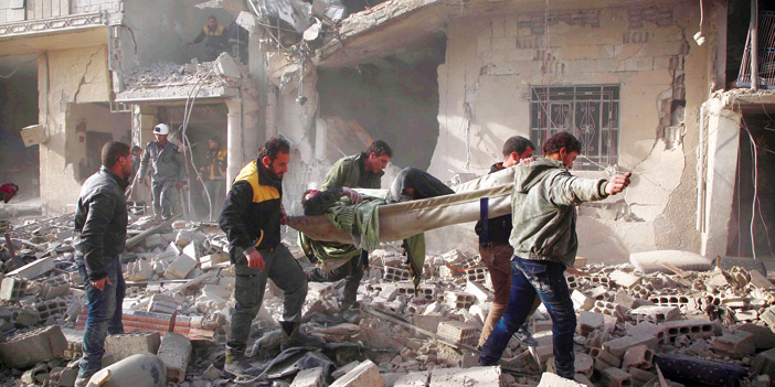   رجال الإنقاذ السوريون يقومون بحمل أحد المصابين من غارات النظام