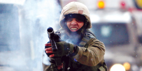   جندي إسرائيلي يطلق قنابل الغازات خلال مواجهات بالضفة الغربية