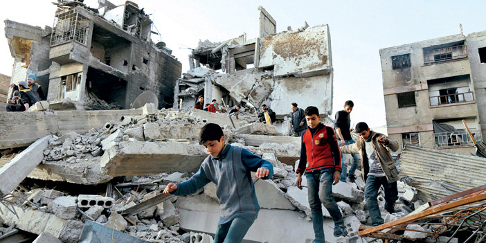   أطفال يمشون بين أنقاض المباني المدمرة والقصف مستمر