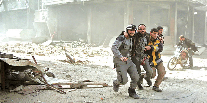  منقذون سوريون يحملون أحد المصابين وهم يهربون من القصف