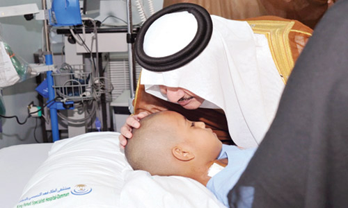  الأمير سعود بن نايف مقبلا جبين طفل خلال الزيارة