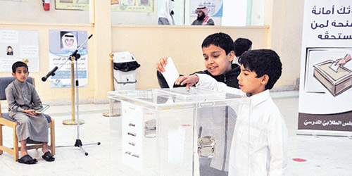  طلاب أمام صندوق الاقتراع للتصويت