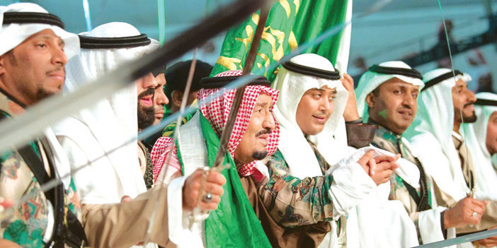 الملك خلال تشريفه حفل أهالي الحدود الشمالية يشارك في العرضة السعودية ومتوشحاً بـ«البيرق»