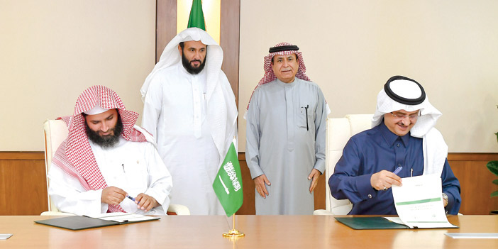  ممثلا الجهتين خلال توقيعهما الاتفاقية