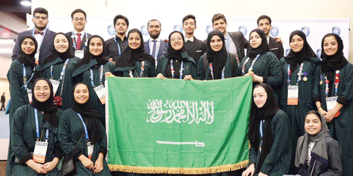  الطلاب والطالبات الفائزون يحملون علم المملكة