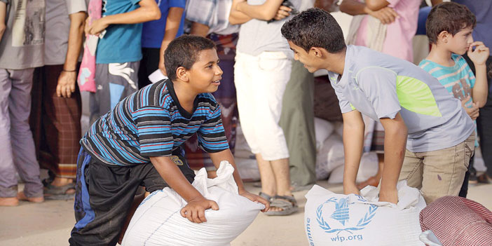  طفلان يبتسمان بعد حصولهما على مساعدات غذائية في عدن