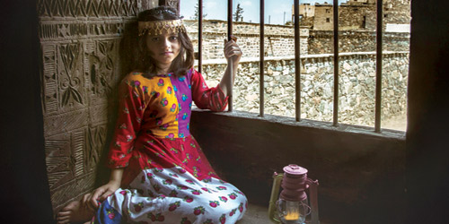  إحدى الفتيات تتزين بملابسها التقليدية في أحد القصور التراثية في الباحة