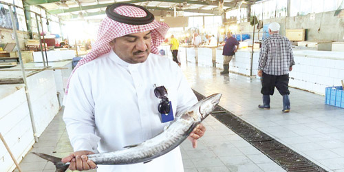  مراقب البلدية يفحص أسماكاً في سوق السمك بالقطيف