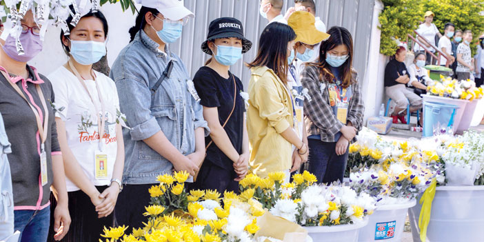  مجموعة من الصينيات يوزعن وروداً وزهوراً في إحدى المدن الصينية