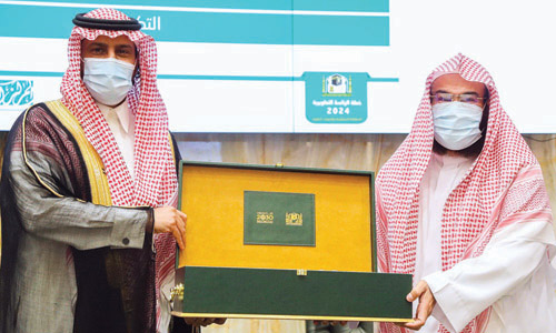  الأمير بندر بن سلمان والشيخ السديس بعد توقيع الاتفاقية