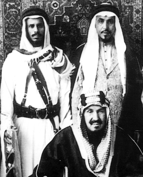  الملك عبدالعزيز ويقف خلفه عبدالرحمن الطبيشي يمين الصورة ومحمد النعيّمة يسارها عام 1362هـ/1943م