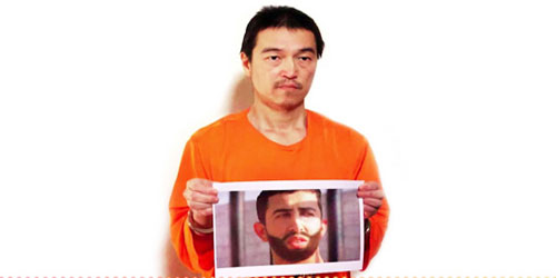  الرهينة الياباني يحمل صورة للطيار الأردني