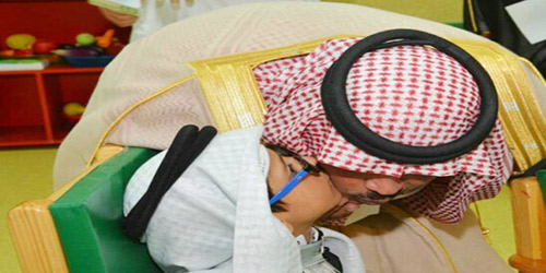  أمير الباحة معانقاً أحد أطفال المركز