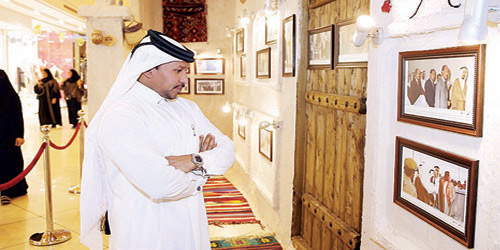  أحد الخليجيين يستعرض صور معرض الملك الراحل عبد الله